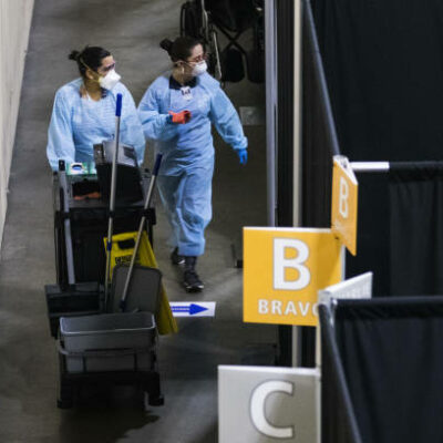 Medical workers wearing protective gear walk through the UMass Memorial Health Care field hospital at the DCU Center in Worcester, Massachusetts, U.S., on Wednesday, April 15, 2020. Covid-19 has infected 2 million people around the world as the new coronavirus marks another grim milestone. Photographer: Adam Glanzman/Bloomberg via Getty Images